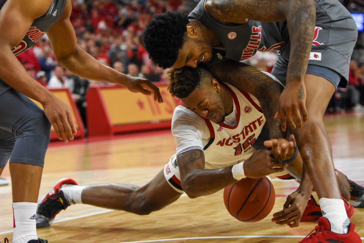 Redshirt freshman forward Manny Bates fights for a loose ball underneath the basket during the game versus the Louisvillle Cardinals on Saturday, Feb. 1, 2020 in PNC Arena. The Wolfpack lost to the Cardinals 77-57.