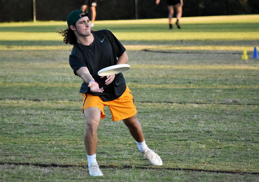 Sophomore Robert McAllister tosses the disc to a teammate to practice his accuracy in preparation for the next game. Men&#8217;s ultimate scrimmages against other teammates to practice backhand leading tosses and tapping the disc at Method Fields on Tuesday, September 24, 2019.