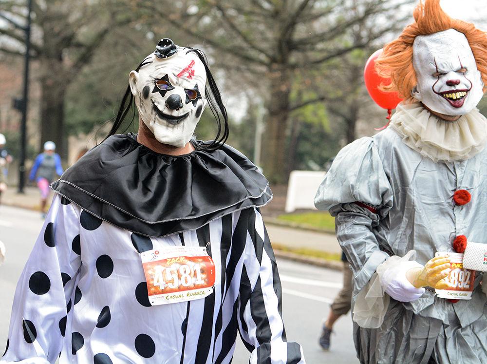 Zack Cook and a runner identified as "Pukie McPukerson" walk along the route during the Krispy Kreme Challenge on Saturday, Feb. 1, 2020.
