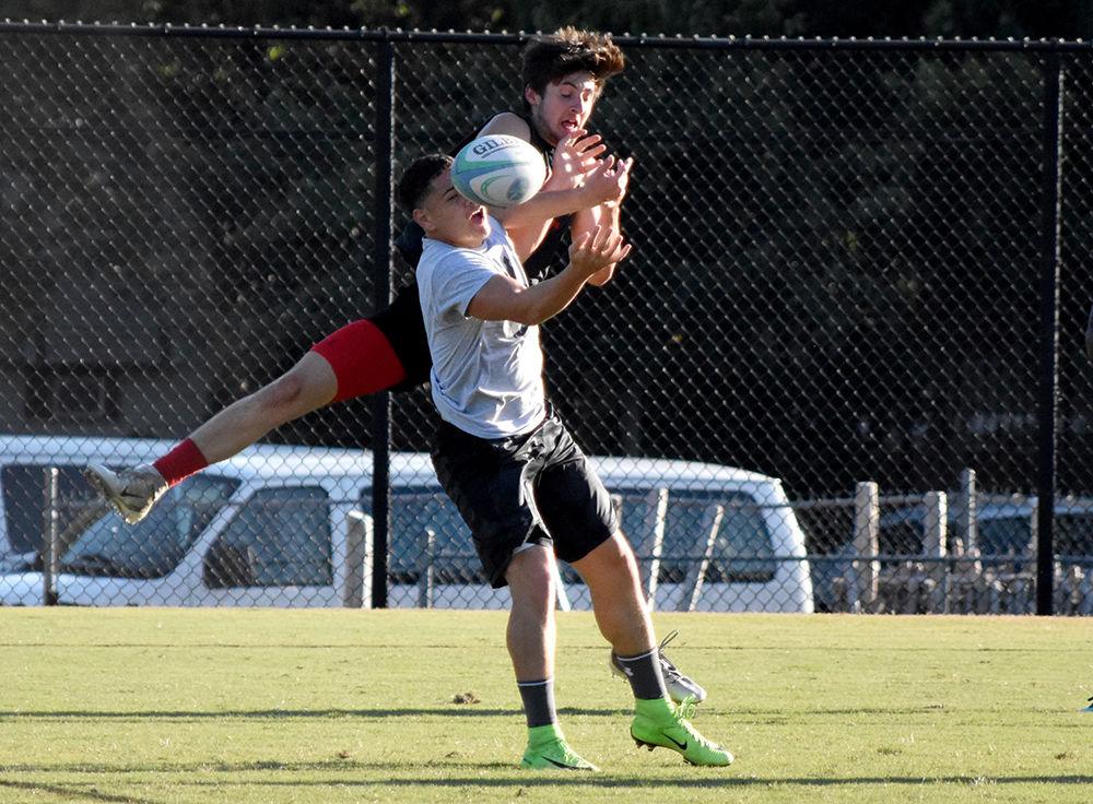 Fourth year Mende Carlton and first year Steven Thompson both jump after the ball to gain possession. Men&#8217;s club rugby scrimmages against their teammates to practice effective passing methods and different ways to avoid the opposing team on Tuesday, September 24, 2019.