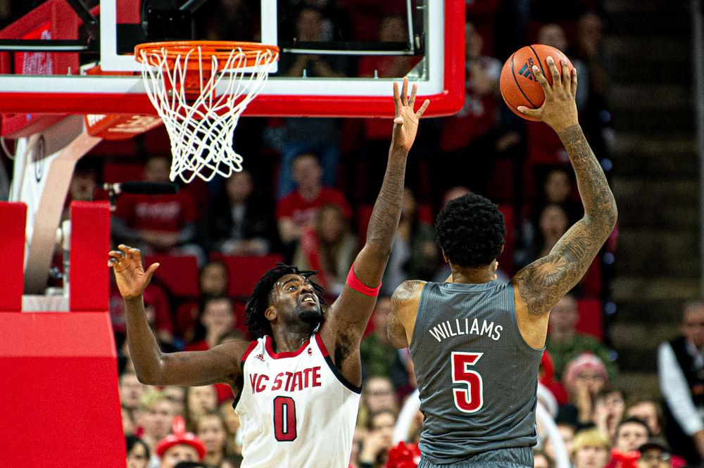 Redshirt junior forward D.J. Funderburk contests a shot by Louisville forward/center Malik Williams on Saturday, Feb. 1, 2020 at PNC Arena. Funderburk recorded 11 points and eight rebounds as the Wolfpack lost 77-57.
