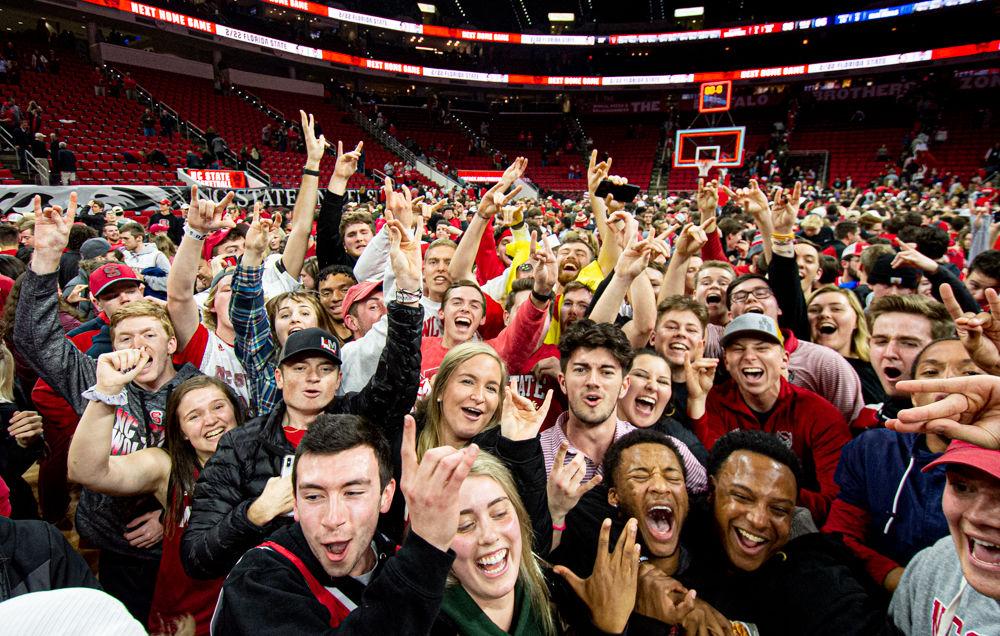 NC State fans celebrate on the court after the Wolfpack&#8217;s 88-66 upset win over No. 6 Duke on Wednesday, Feb. 19, 2020 at PNC Arena.