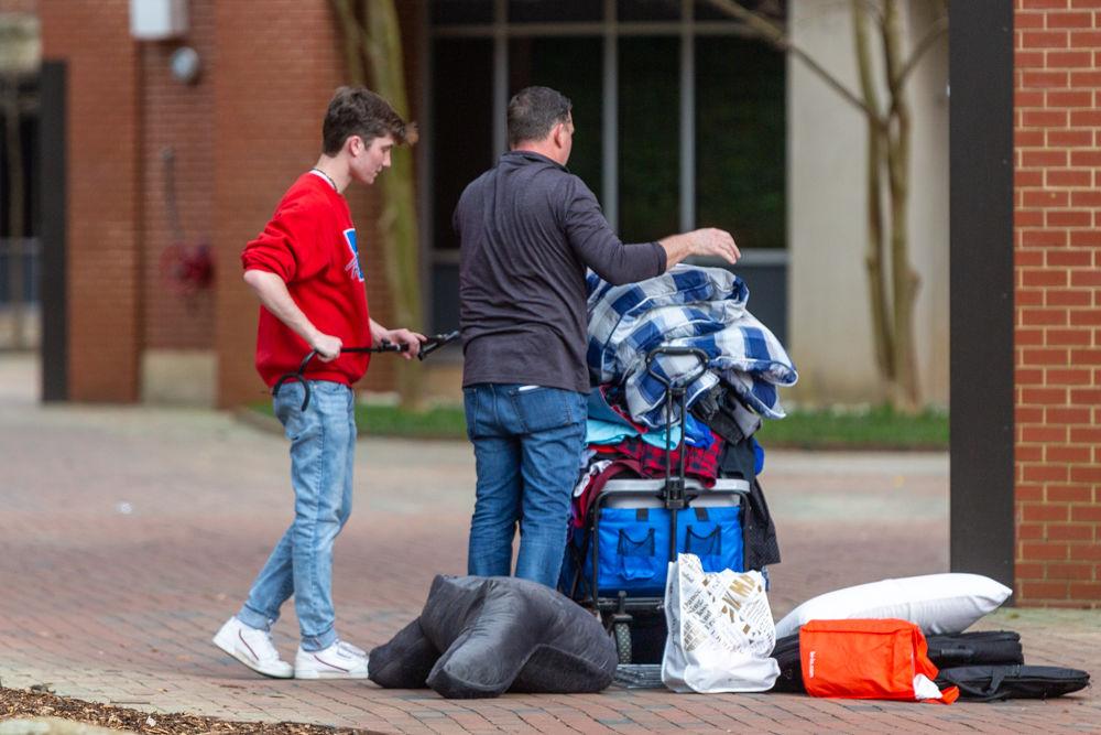 Students and parents move belongings back to their cars during an early move-out for students on Tuesday, March 17, 2020 at Thurman drive. Students were informed earlier on March 17 that the campus would be moving to minimal operations and that dorms would be closing until further notice in an attempt to safeguard against and prevent the spread of the COVID-19 virus. Students have until 5 P.M. on Sunday, March 22, 2020 to take their essentials and return to their permanent residences, with an exception for a few categories of students.