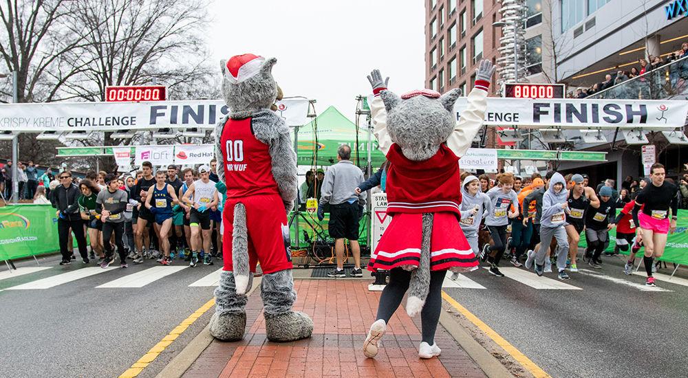 Mr. and Mrs. Wuf cheer on the runners during the Krispy Kreme Challenge Saturday, Feb. 1, 2020 at the Memorial Bell tower.