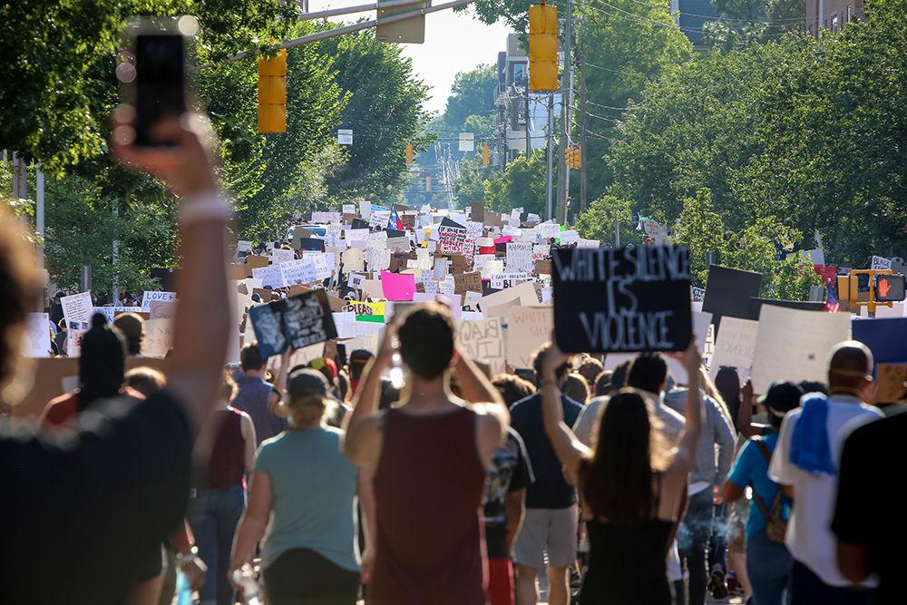 Protesters carry signs down W Jones St. as they make their way around downtown Raleigh during the protests against police violence on Saturday, May 30, 2020. The nationwide protests against the killing of George Floyd by police in Minnesota have led to a week of riots and violence.