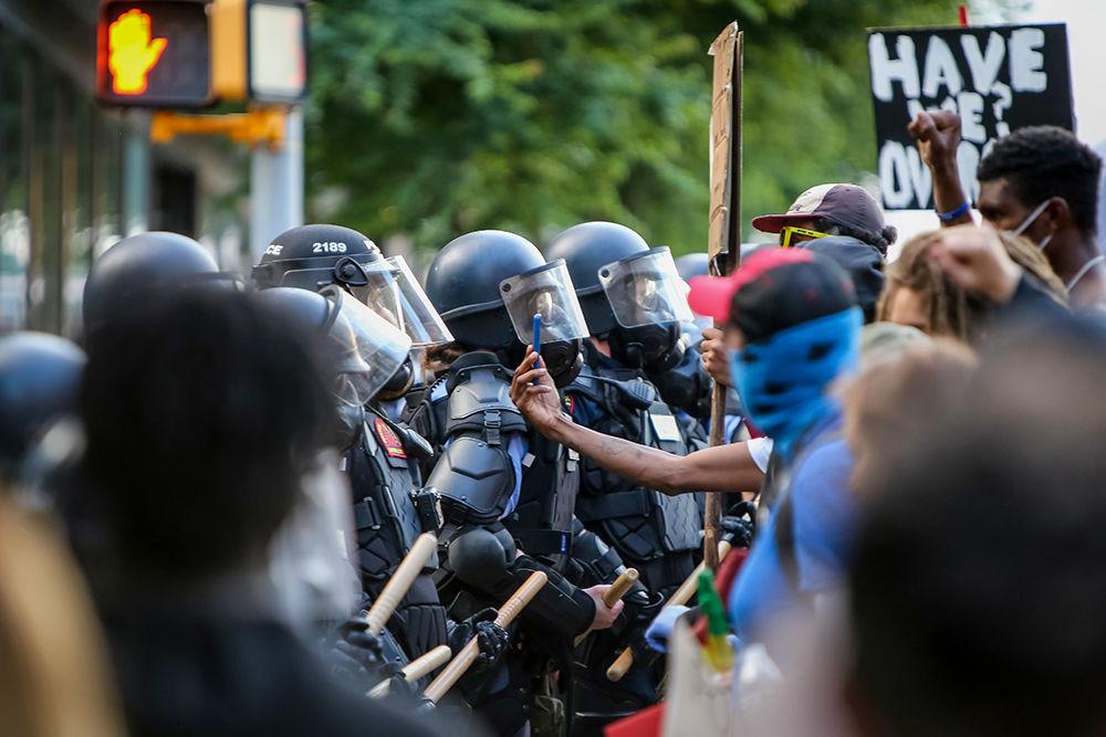 A protester records video of police in riot gear during the protests in downtown Raleigh against police violence on Saturday, May 30, 2020. The nationwide protests against the killing of George Floyd by police in Minnesota have led to a week of riots and violence.