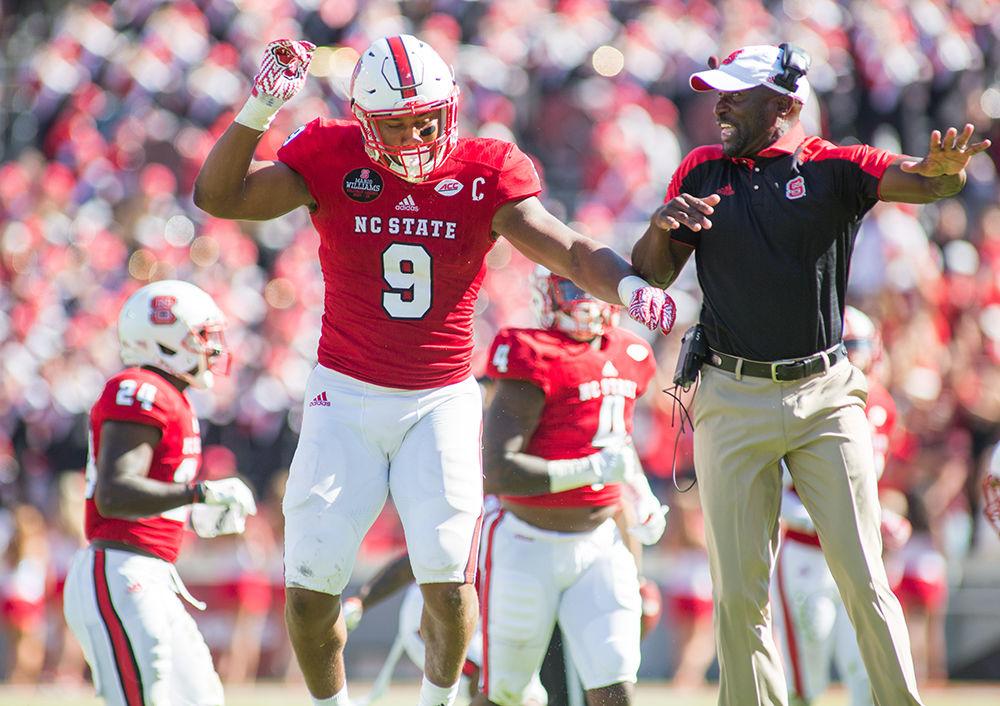 Junior defensive end Bradley Chubb and Assistant Head Coach for Defense George Barlow celebrate after forcing a turnover on downs. Chubb was felt all over the field with a tackle for a loss, a breakup, and a forced fumble during the 21-14 homecoming loss to Boston College on Oct. 29, 2016 in Carter Finley Stadium.