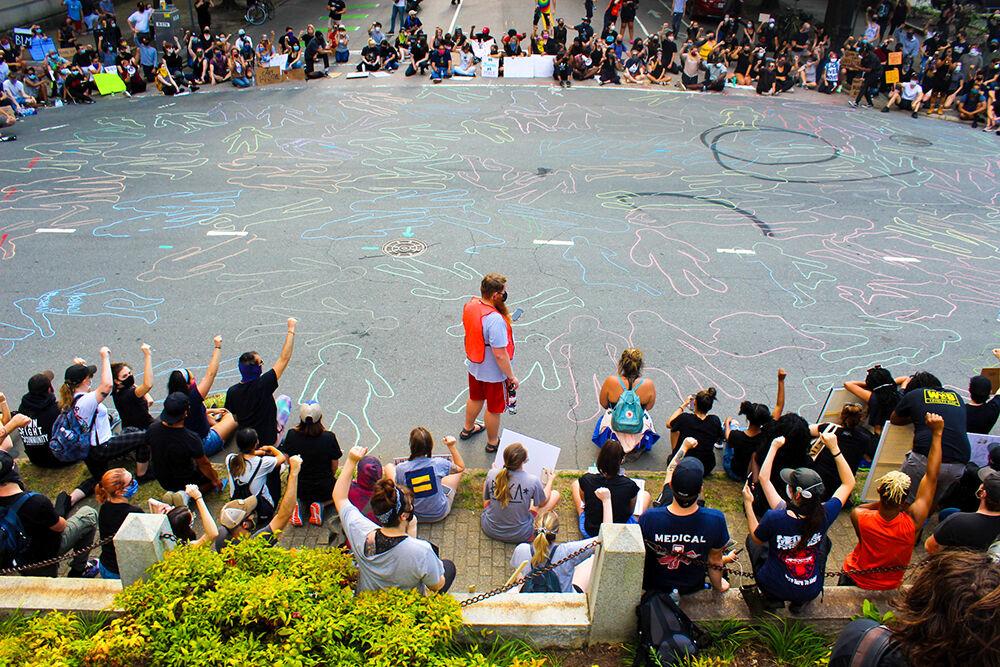 Chalk outlines cover the pavement during the peaceful protest in Raleigh on Tuesday, June 3, 2020.