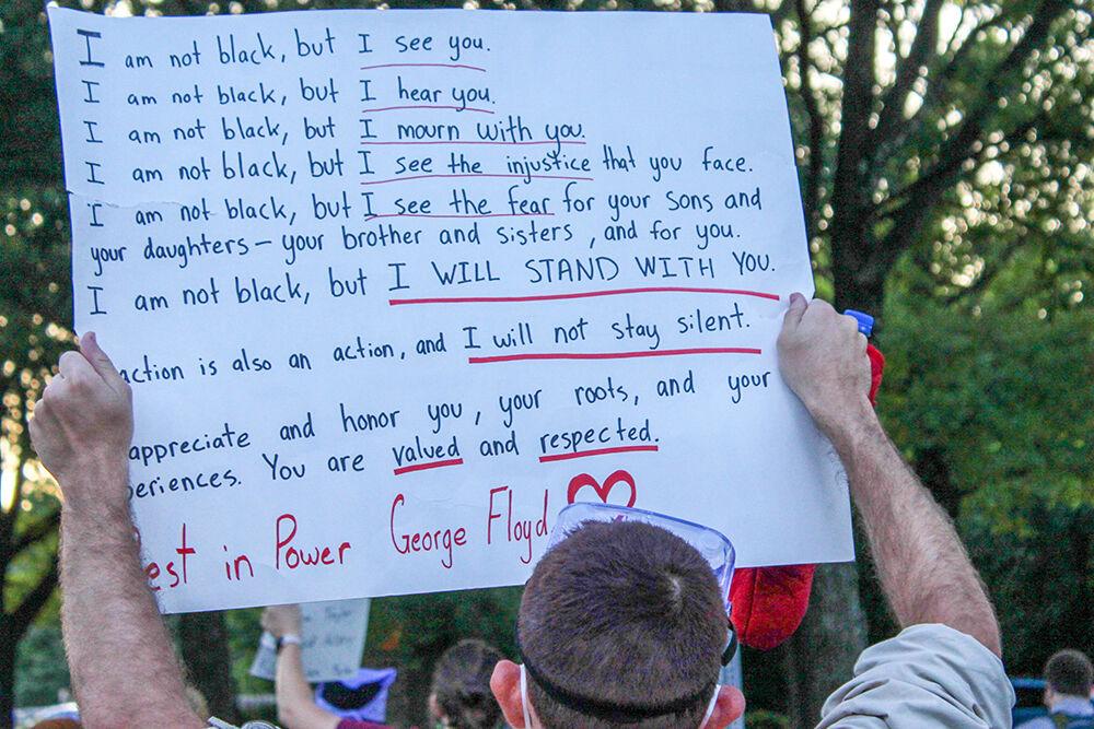 A protester holds a sign in solidarity with Black Lives Matter during the protest in Raleigh on Monday, June 1, 2020. The protest was peaceful during its duration.