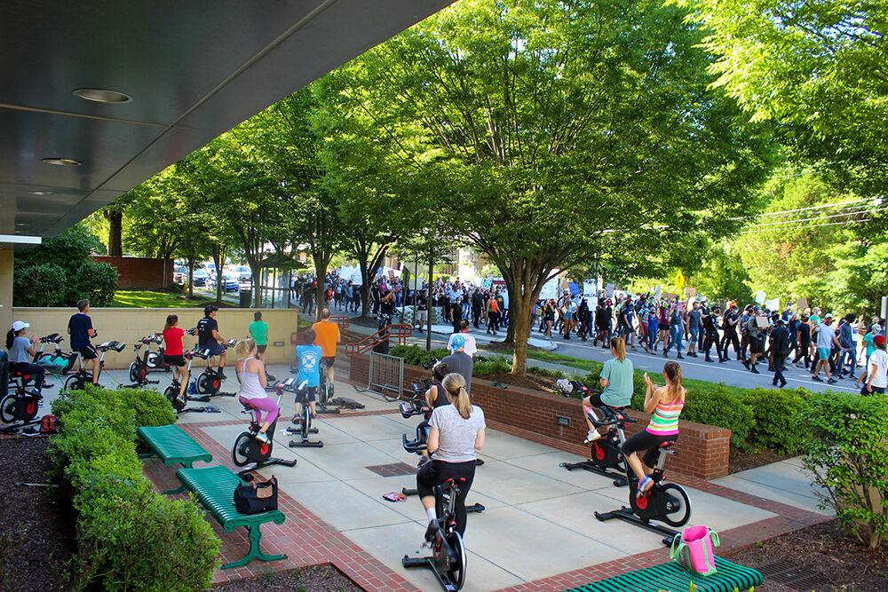 A cycling class watches as the Black Lives Matter protest marches on in Raleigh on Monday, June 1, 2020.