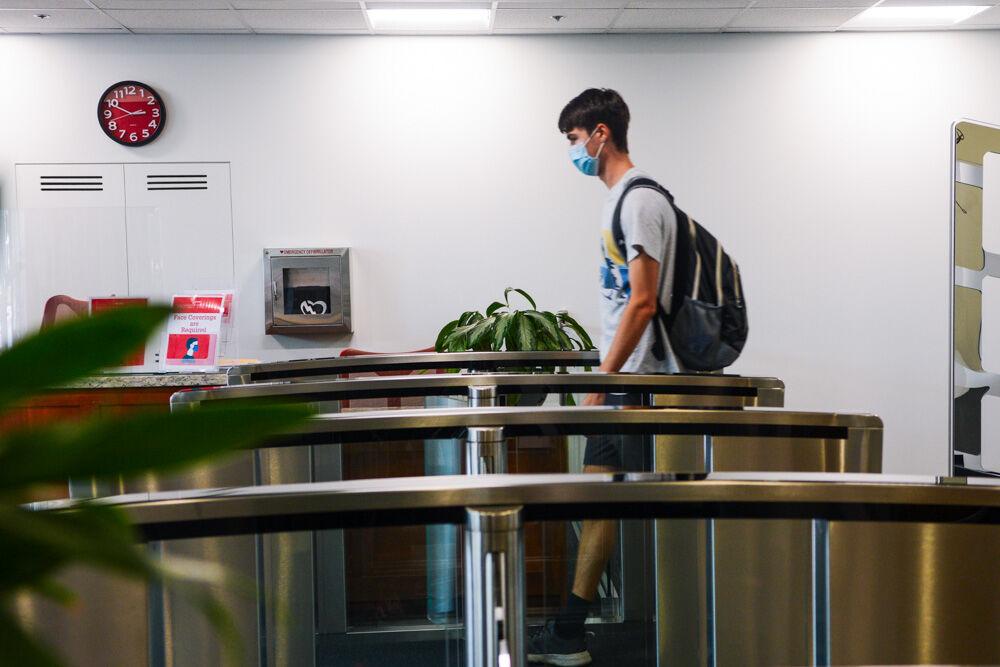 Cameron Seitz, a first-year studying engineering, exits through the new entrance at D.H. Hill Library on Tuesday, Aug. 18, 2020. Social distancing requirements include marked walking pathways and hand-sanitizing stations.