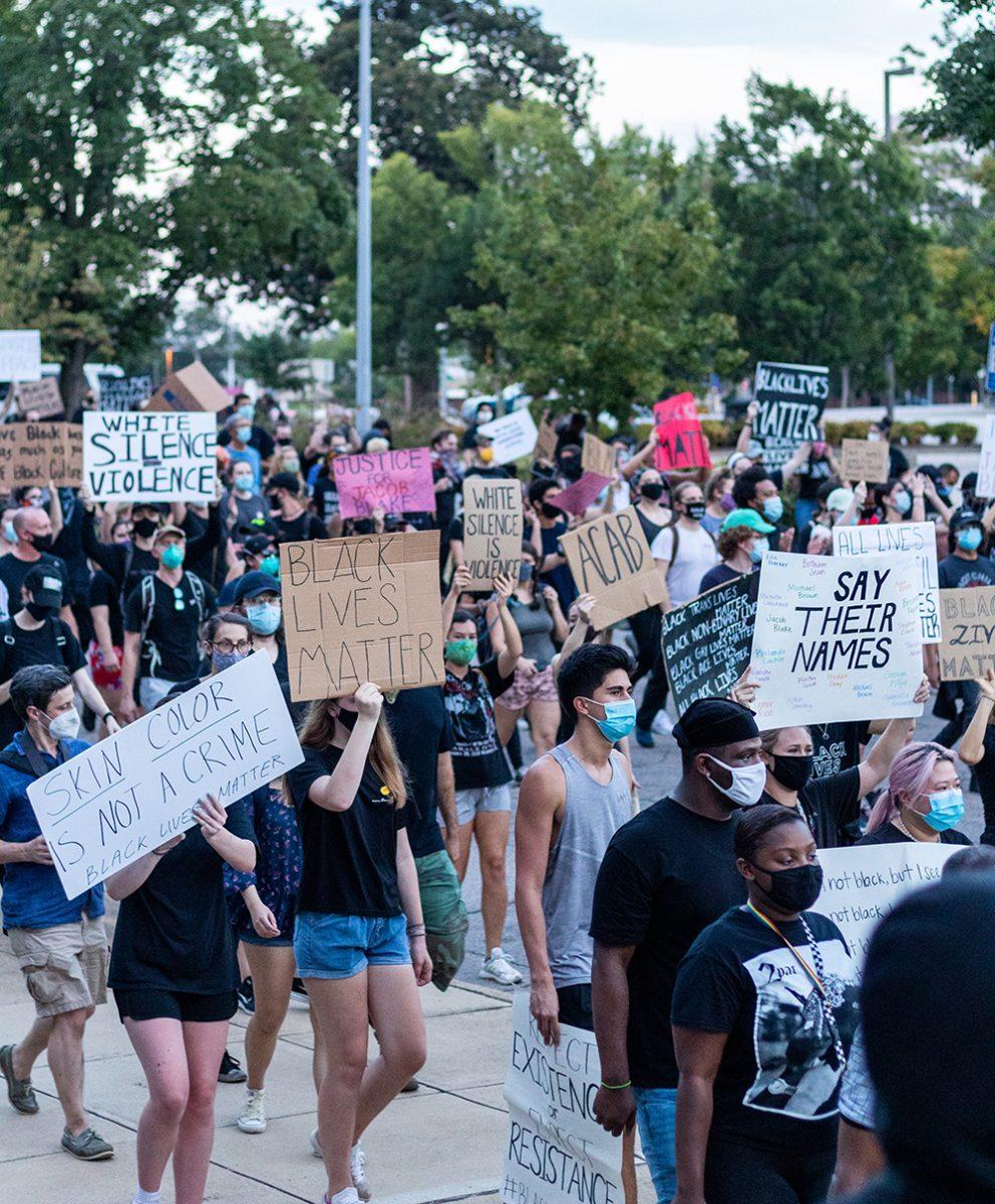 Protesters walk by the North Carolina Arts Council building in downtown Raleigh on Friday, Aug. 28, 2020. Many protesters carried signs, some of which read "ACAB" and "Black Lives Matter" and "Say Their Names."