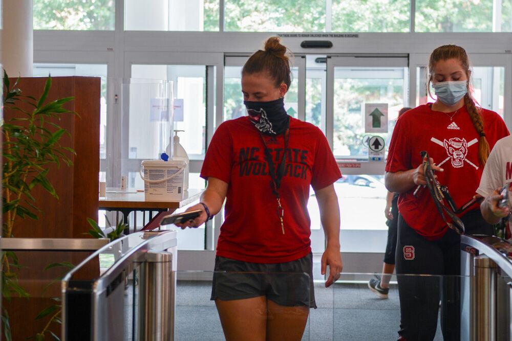 Grace Johnson, a second-year studying business, and Brooklyn Lucero, a first-year studying biology, swipe their student IDs to enter D.H. Hill Library on Tuesday, Aug. 18, 2020. Due to the coronavirus pandemic the library is only open to students and no longer open to the public.