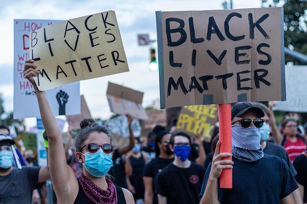Two protesters hold make-shift signs that read Black Lives Matter during the Raleigh community march on Friday, Aug. 28, 2020. This march was organized by NCBorn, a collection of Raleigh community members.