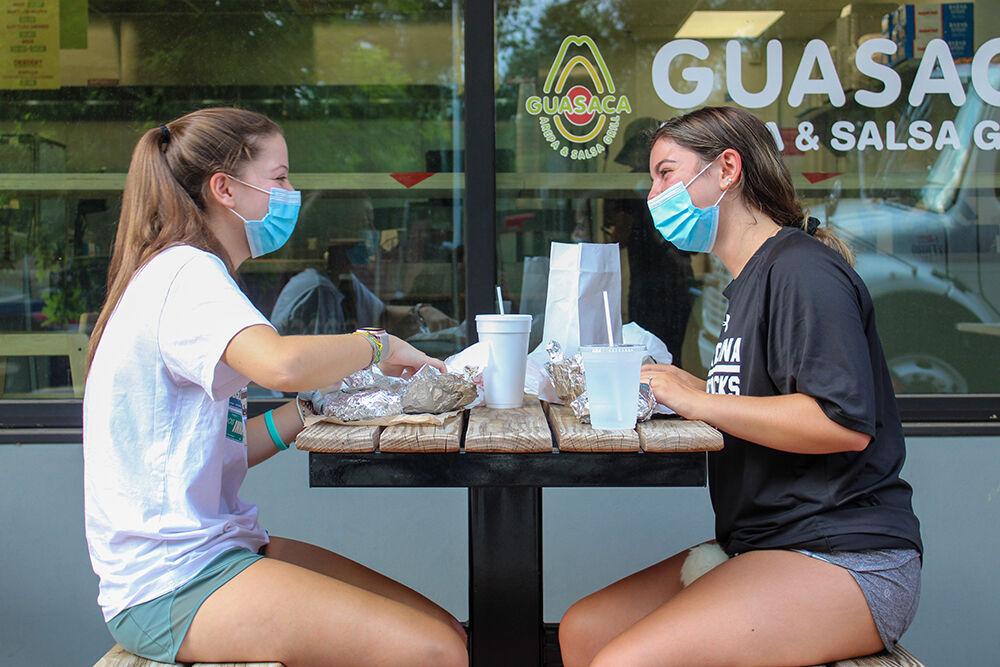 Caroline Schollaert, a first year from Elon University, and Teagan Hackim, a first year from South Carolina University, both enjoy their meals at Guasaca on Hillsborough Street on Aug. 10, 2020. Many restaurants have been taking steps in order to insure the safety of their customers during the COVID-19 pandemic.