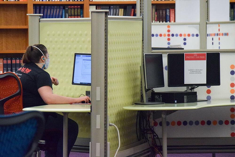 Abigail Cordiner, a third-year studying chemical engineering, studies at D.H. Hill Library on Saturday, Aug. 22, 2020. The computer across from her is blocked off, ensuring people stay 6 feet apart.