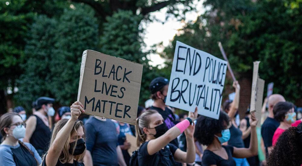 Protesters hold up signs reading "Black Lives Matter" and "End Police Brutality" during the Black Lives Matter Raleigh community march on Friday, Aug. 28, 2020. The protesters marched for Jacob Blake to receive justice, along with marching in solidarity with Kenosha, Wyoming.
