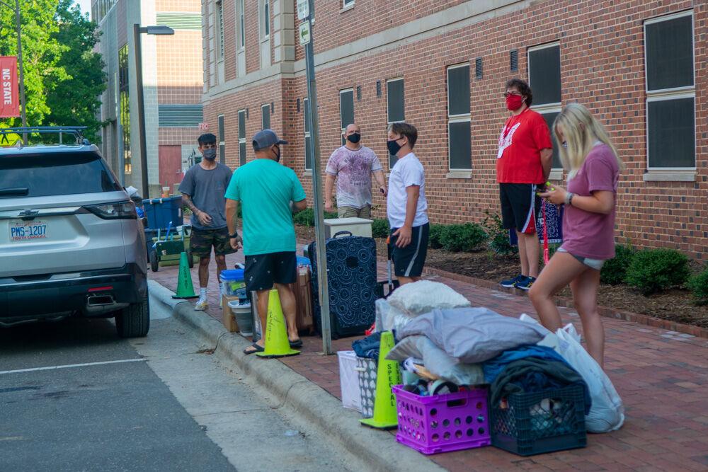 Students and their families unload belongings on the curb next to Tucker Residence Hall on Saturday, Aug. 1, 2020. Students were assigned move in slots to allow for social distancing within the dorms.