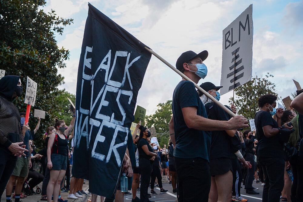 Victor Lytvinenko, a Raleigh native, holds a homemade flag at the BLM Community March in downtown Raleigh on Friday, Aug. 29, 2020. The march called for justice for Jacob Blake, and stood in solidarity with the protests in Kenosha, WI.
