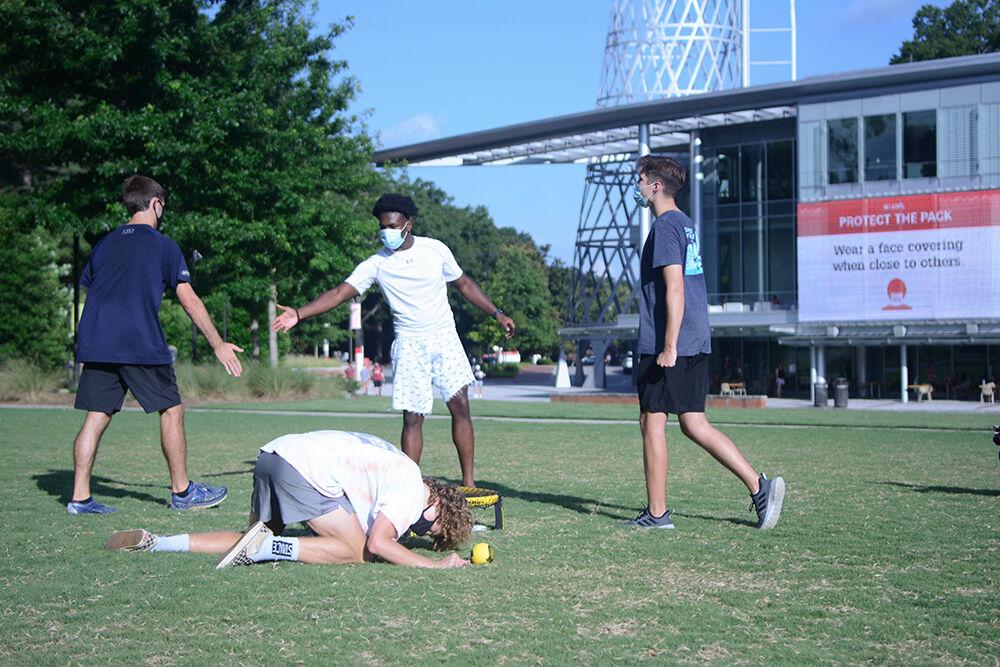 Shane Ticcett, a second-year studying math, William Simas, a second-year studying sustainable materials and technology, Darius Ledbetter, a second-year studying environmental technology management, and Parker Shelton, a second-year studying business, play a lively game of Spikeball outside of Talley Student Union on Tuesday, Aug. 11, 2020. Ticcett crashed down in distress as he missed the shot.
