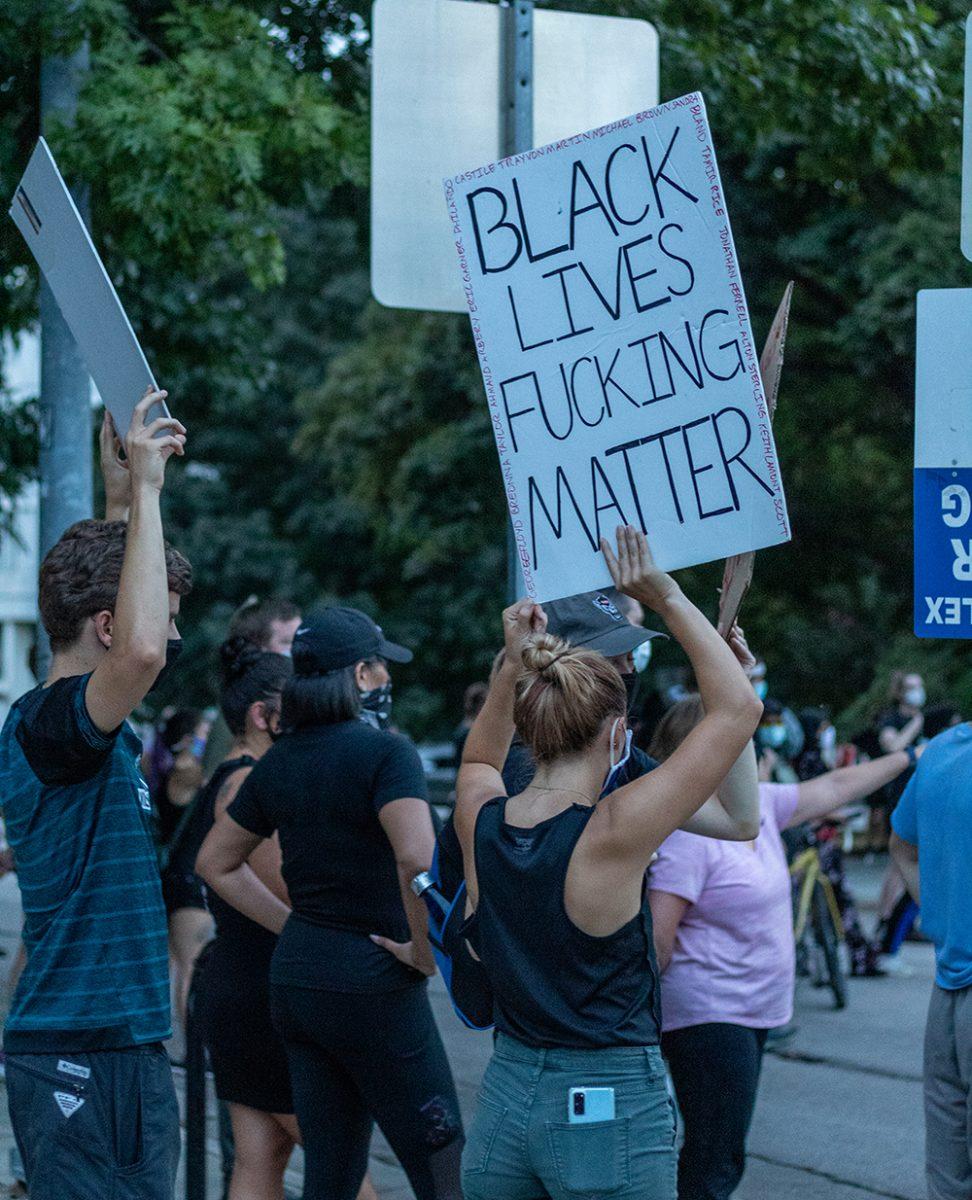 A protester holds up a sign during the Black Lives Matter protest in downtown Raleigh on Friday, Aug. 28, 2020. The march called for an end to police brutality that has systematically and historically affected people of color, especially African Americans.