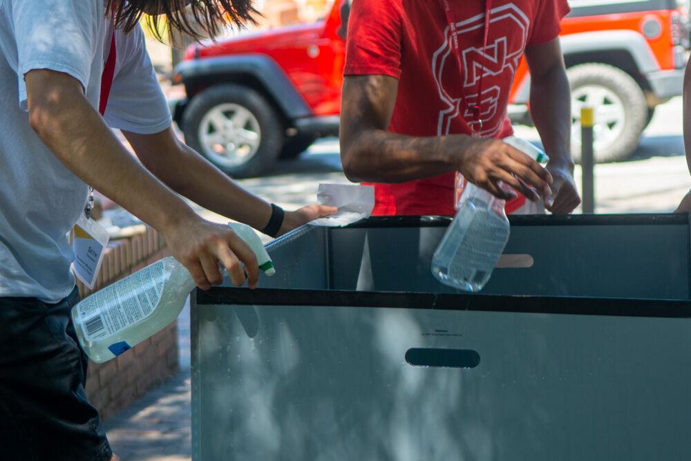 The Resident Advisors for the Tri-Towers sanitize luggage bins in between use during the first day of move in on Friday, July 31, 2020. Students were assigned specific move in appointments to reduce the amount of traffic in the dorms due to COVID-19.