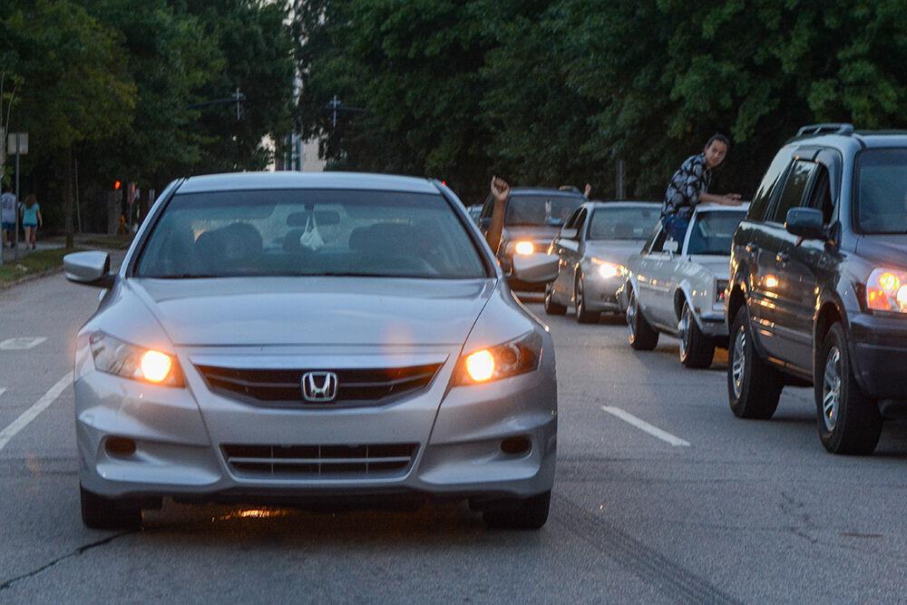 Those stopped in traffic due to the Black Lives Matter Community March in downtown Raleigh raise their fists in solidarity on Friday, Aug. 28, 2020. The march walked to end police brutality and bring awareness to racial issues.