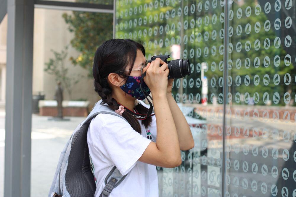 Quynh Vo, a first-year studying graphic design, takes a photo in the reflection of Talley Student Union during the photo walk on Saturday, Aug. 8th, 2020. The photo walk gave students the opportunity to explore campus while learning about camera basics.