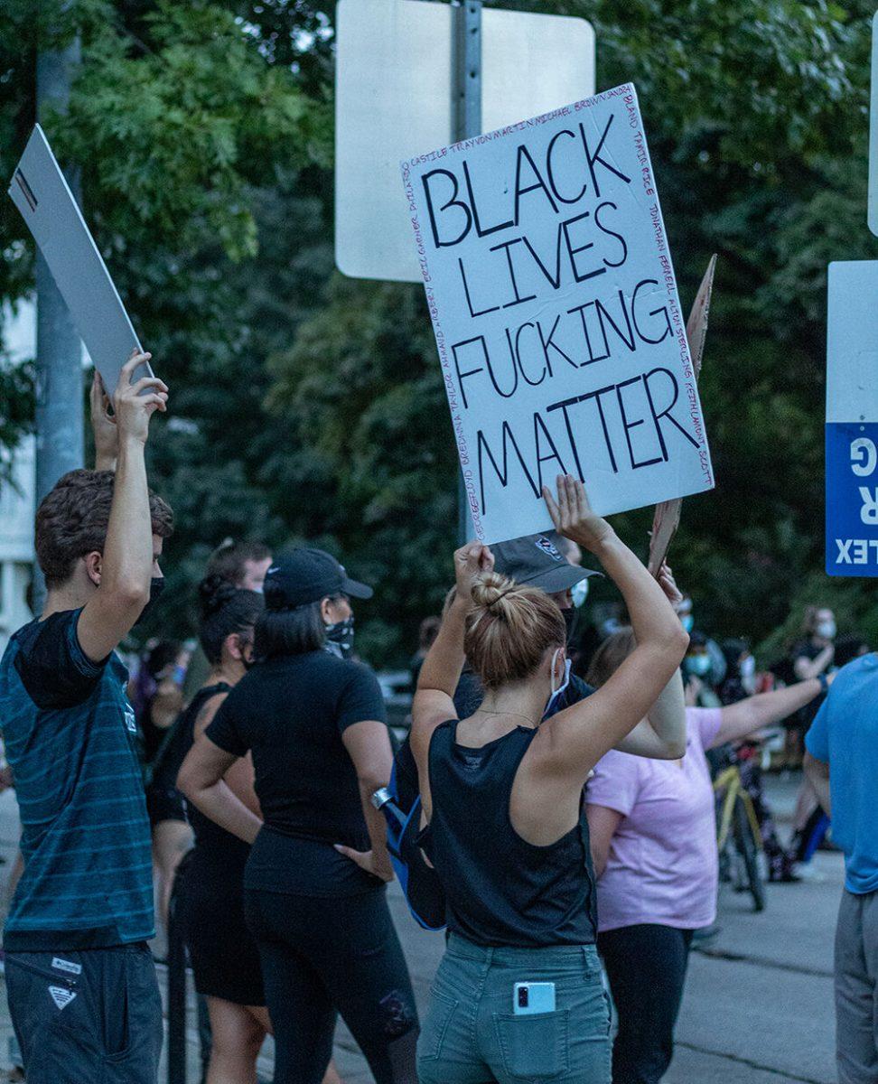 A protester holds up a sign during the Black Lives Matter protest in downtown Raleigh on Friday, Aug. 28, 2020. The march called for an end to police brutality that has systematically and historically affected people of color, especially African Americans.