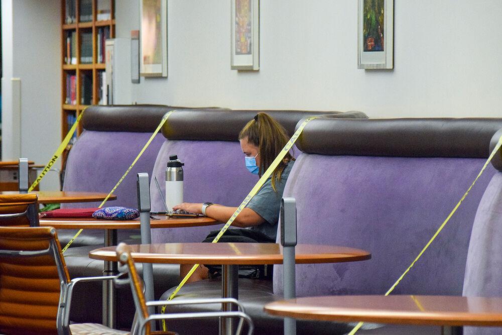 Amy Karns, a second-year studying business administration, writes her paper at D.H. Hill Library on Saturday, Aug. 22, 2020. The seats surrounding her are blocked off to ensure social distancing.