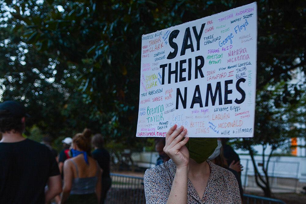A protester holds a sign displaying the names of the victims of police brutality at the Black Lives Matter Community March downtown Raleigh on Friday, Aug. 28, 2020. The march called for an end to police brutality and reforms within the Raleigh Police Department.