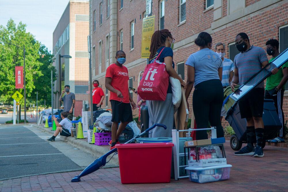 Students and their families unload belongings on the curb next to Tucker Residence Hall on Saturday, Aug. 1, 2020. Students were assigned move in slots to allow for social distancing within the dorms.