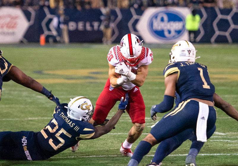 NC State freshman running back Jordan Houston protects the ball while being tackled during NC State's game against Georgia Tech at Bobby Dodd Stadium on Nov. 22, 2019. The Wolfpack lost, 28-26.