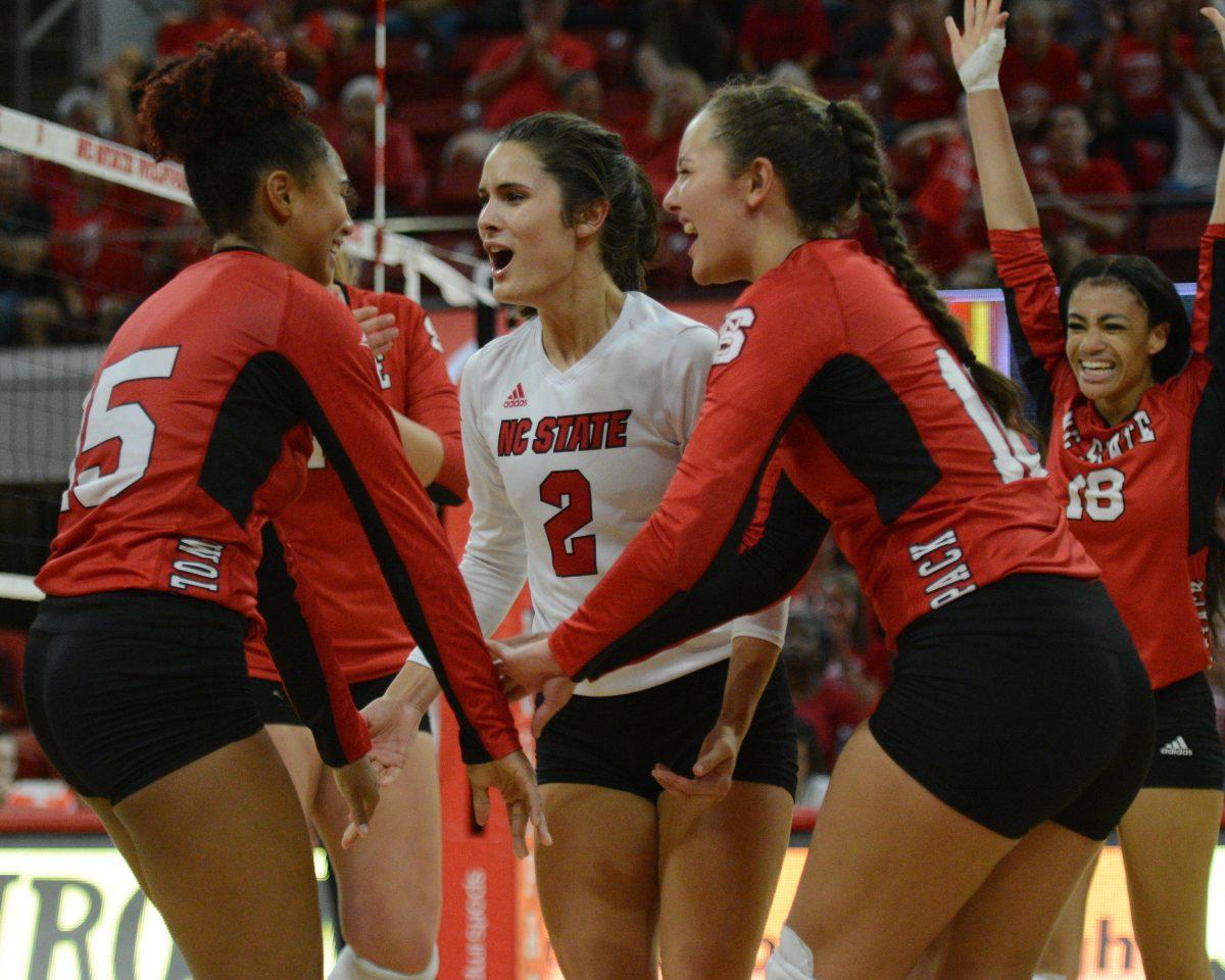 Teammates Grace Irvin and Savannah Bryant celebrate sophomore, outside hitter, Jade Parchment&#8217;s kill against UNC on Oct. 2 in Reynolds Coliseum. Parchment played in five sets and had 14 kills, one ace and ten digs in the 3-2 loss to UNC.