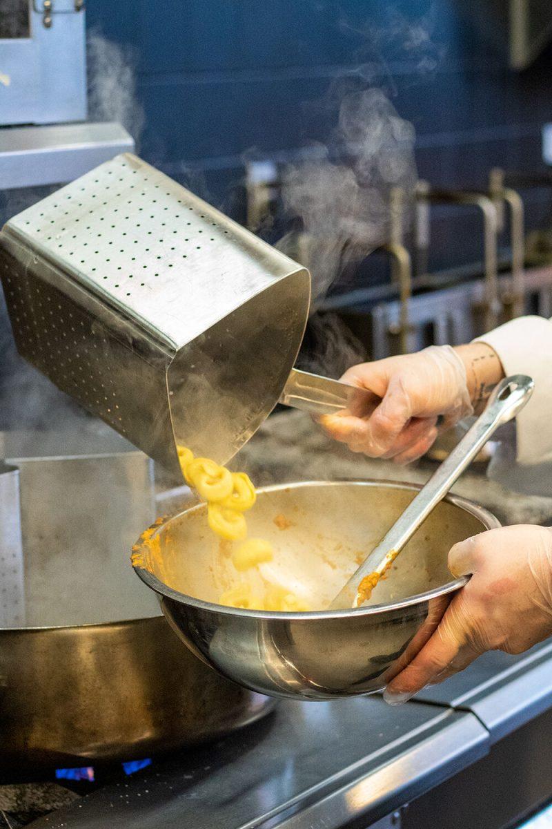 Hector Vega Jr, the Executive Sous-Chef of 1887 Bistro, pours macaroni into a mixing bowl in the kitchen of 1887 Bistro on Wednesday, Sept. 23, 2020.