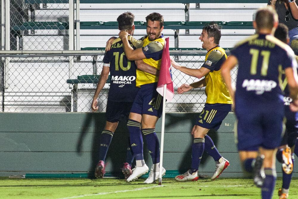 The North Carolina FC team converges on midfielder Nazmi Albadawi after his goal in the 89th minute. NCFC would take down Memphis 901 3-2 on Sunday, Sept. 13 in WakeMed Soccer Park.