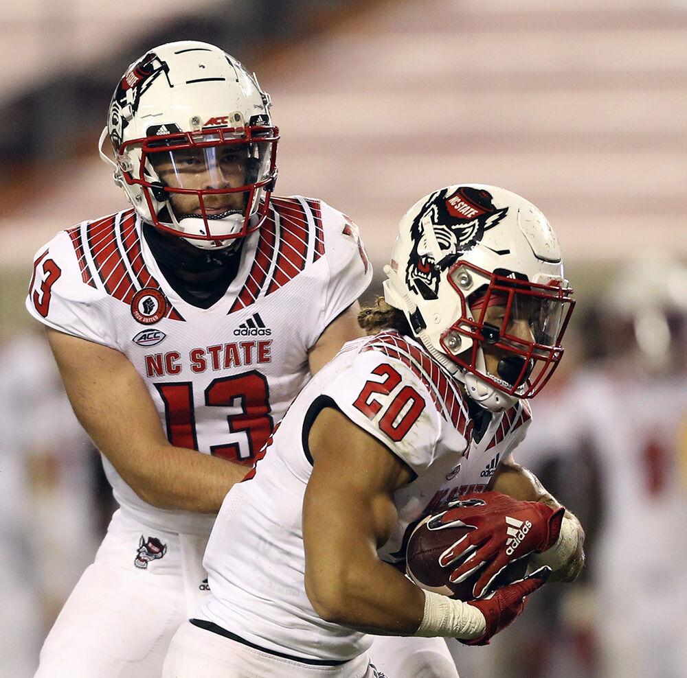 NC State quarterback Devin Leary 13 hands off to running back Jordan Houston 20 for a touchdown run in the second half of the Virginia Tech - North Carolina State NCAA football game in Blacksburg Va. Saturday September 26 2020. Virginia Tech won the game 45-24.(AP Photo / The Roanoke Times, Matt Gentry, Pool))
