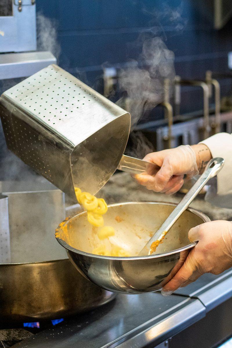 Hector Vega Jr, the Executive Sous-Chef of 1887 Bistro, pours macaroni into a mixing bowl in the kitchen of 1887 Bistro on Wednesday, Sept. 23, 2020.
