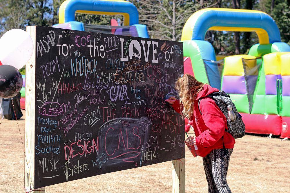 Kathryn Kittrell, a third-year in fashion and textile management, writes on a chalkboard at Stafford Commons for NC State&#8217;s Day of Giving on Wednesday, March 27, 2019
