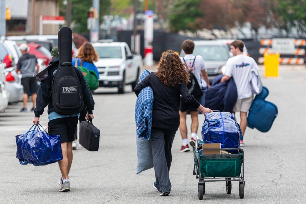 Students and parents move belongings back to their cars during an early move-out for students on Tuesday, March 17, 2020 at Thurman drive.