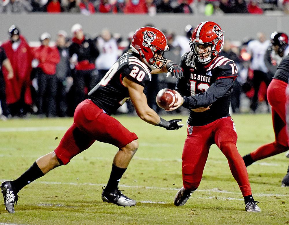Redshirt freshman quarterback Devin Leary hands the ball off to freshman running back Jordan Houston during the game against Louisville on Saturday, Nov. 16, 2019 at Carter-Finley Stadium. Houston had a total of 29 reception yards during the game. Louisville beat NC State 34-20.