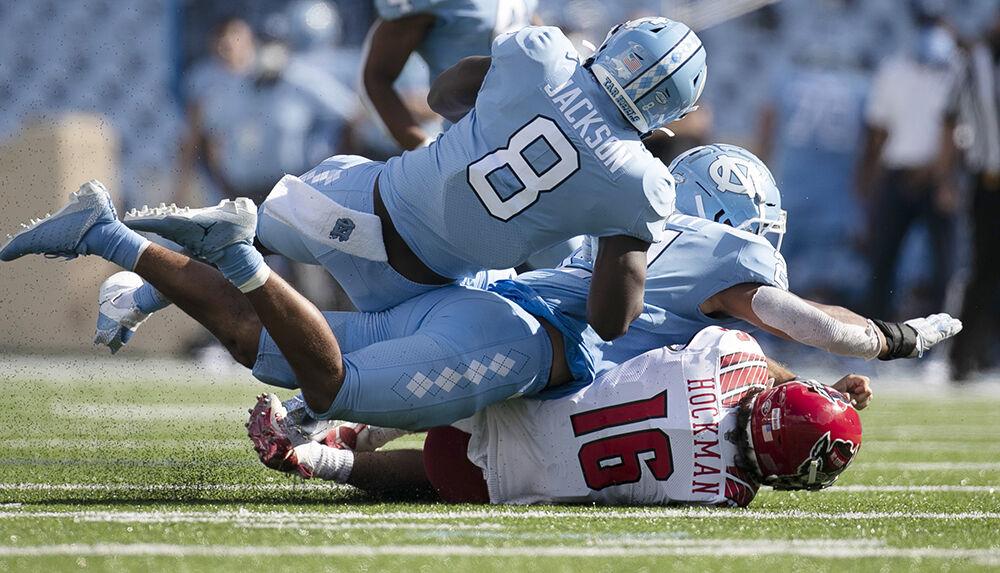N.C. State quarterback Bailey Hockman (16) is sacked by North Carolina's Chazz Surratt (21) and Khadry Jackson (8) in the fourth quarter at Kenan Stadium on Saturday, October 24, 2020 in Chapel Hill, N.C.