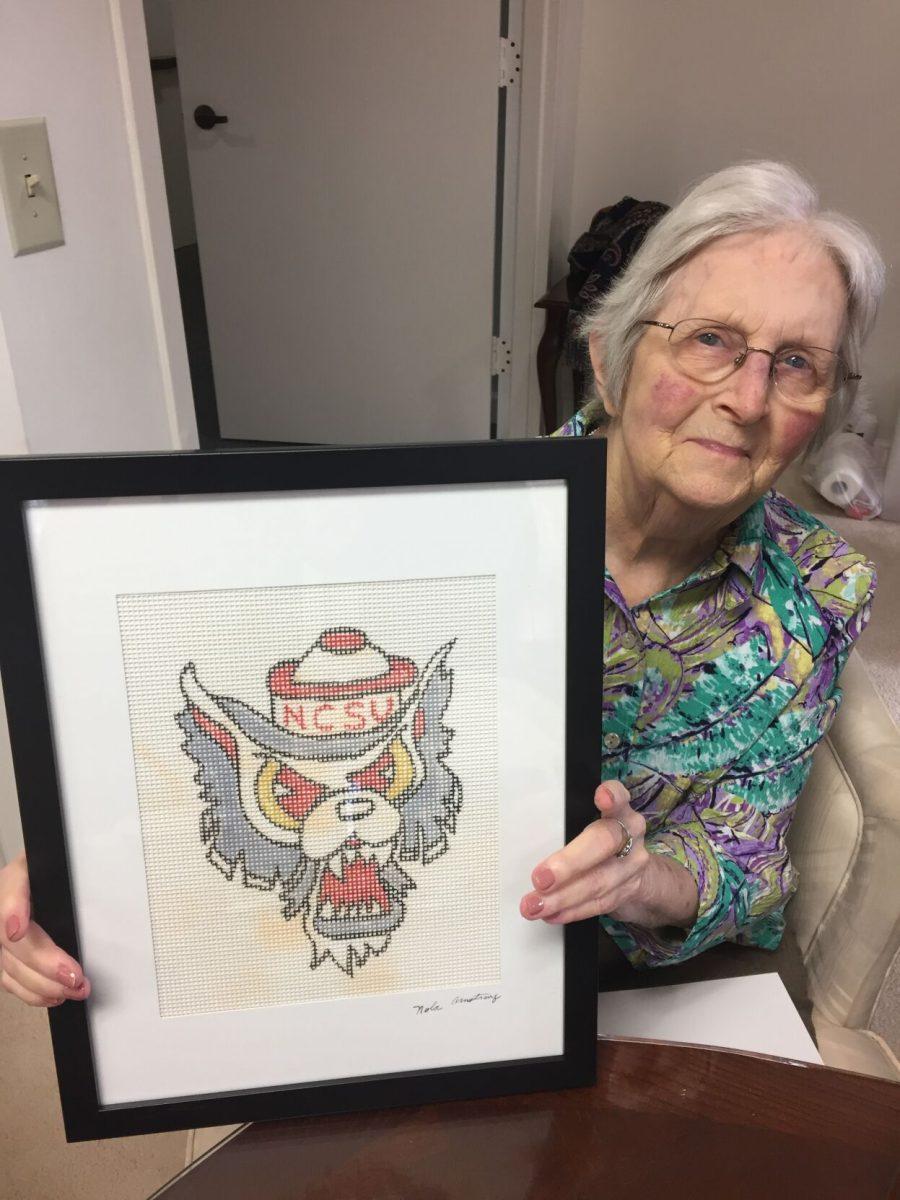 Nola Armstrong holds one of her needlepoint kit designs that were sold in the NC State Student Supply Store in the 1970s.&#160;