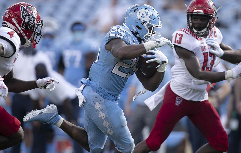North Carolina's Javonte Williams (25) scores on a 27-yard run in the fourth quarter to give the Tar Heels' a 45-14 lead over N.C. State in the fourth quarter at Kenan Stadium on Saturday, October 24, 2020 in Chapel Hill, N.C.