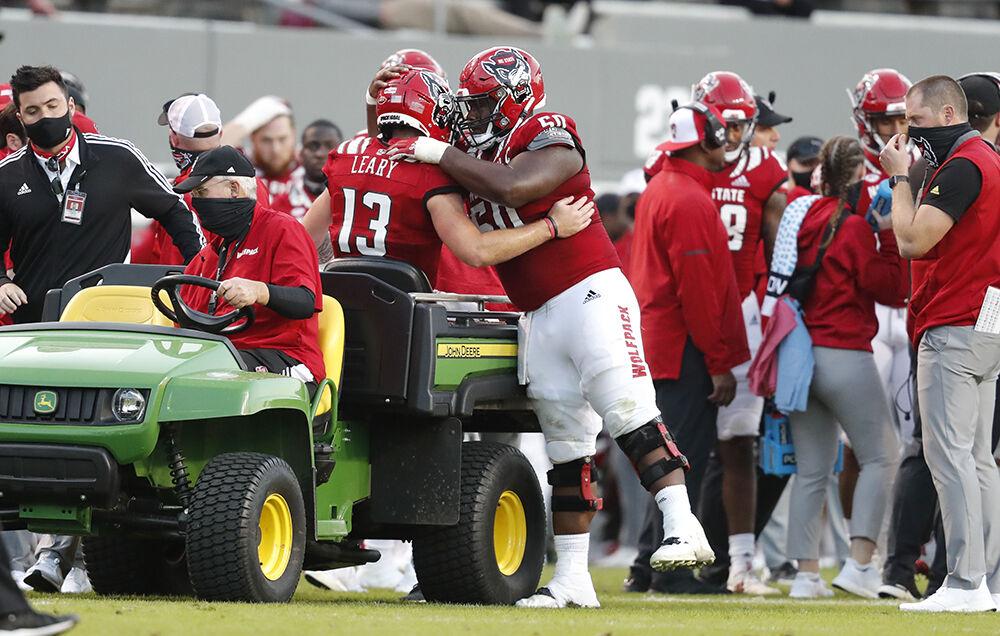 N.C. State&#8217;s Grant Gibson (50) hugs quarterback Devin Leary (13) as he is taken off the field after being injured during the second half of N.C. State&#8217;s 31-20 victory over Duke at Carter-Finley Stadium in Raleigh, N.C., Saturday, Oct. 17, 2020.
