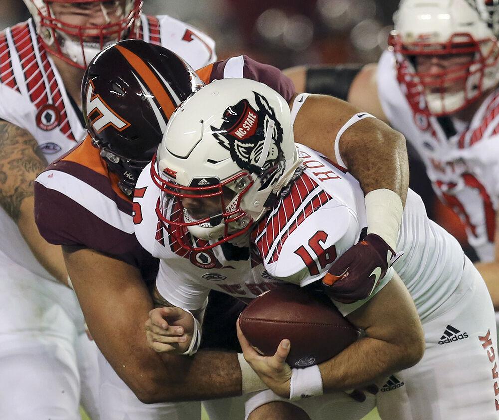 Bailey Hockman 16 of NC State is sacked by Justus Reed 9 of Virginia Tech during the Virginia Tech - North Carolina State NCAA football game in Blacksburg Va. Saturday September 26 2020. (AP Photo / The Roanoke Times, Matt Gentry, Pool)