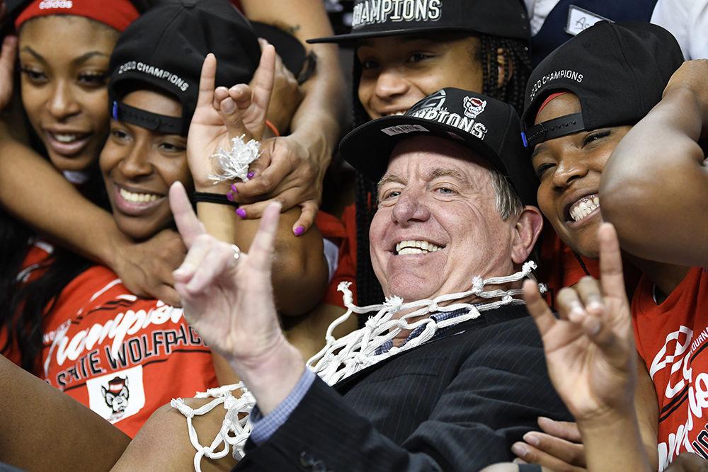 Head coach Wes Moore holds up a wolfie surrounded by his team after their win over the Florida State Seminoles to clinch the 2020 ACC Tournament title on Sunday, March 8, 2020 in the Greensboro Coliseum. The Wolfpack beat the Seminoles 71-66 to win their first ACC title since 1991.