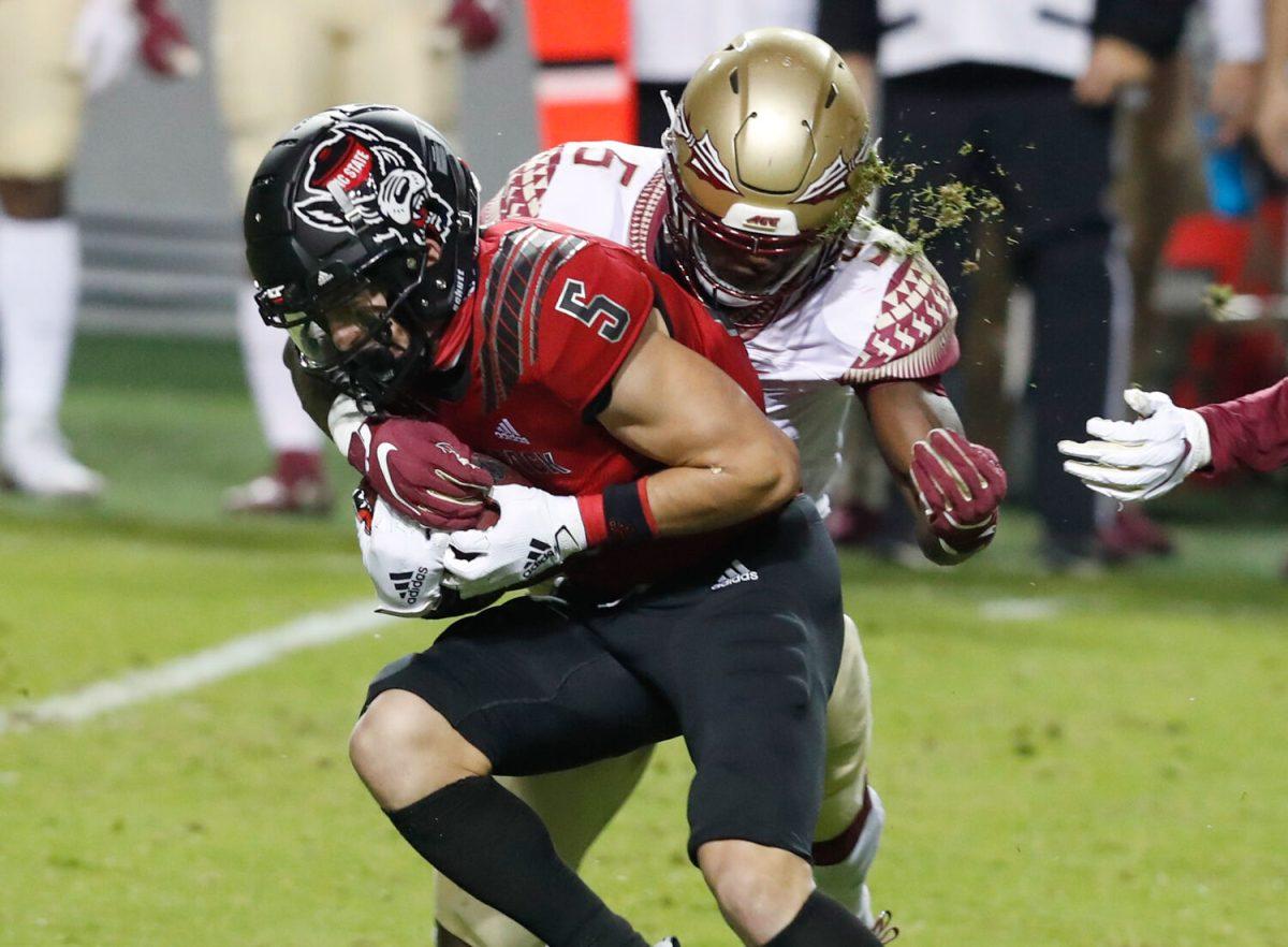 N.C. State wide receiver Thayer Thomas (5) gains yards after making the reception as Florida State defensive back Hamsah Nasirildeen (5) tries to tackle him during the first half of N.C. State&#8217;s game against Florida State at Carter-Finley Stadium in Raleigh, N.C., Saturday, Nov. 14, 2020.