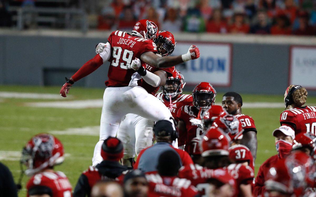 N.C. State defensive lineman Daniel Joseph (99) celebrates with linebacker Isaiah Moore (1) after Moore forced a safety during the second half of N.C. State&#8217;s 15-14 victory over Liberty at Carter-Finley Stadium in Raleigh, N.C., Saturday, Nov. 21, 2020.