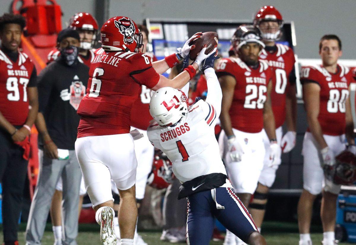 N.C. State tight end Cary Angeline (6) pulls in the reception from Liberty safety Javon Scruggs (1) during the first half of N.C. State&#8217;s game against Liberty at Carter-Finley Stadium in Raleigh, N.C., Saturday, Nov. 21, 2020.